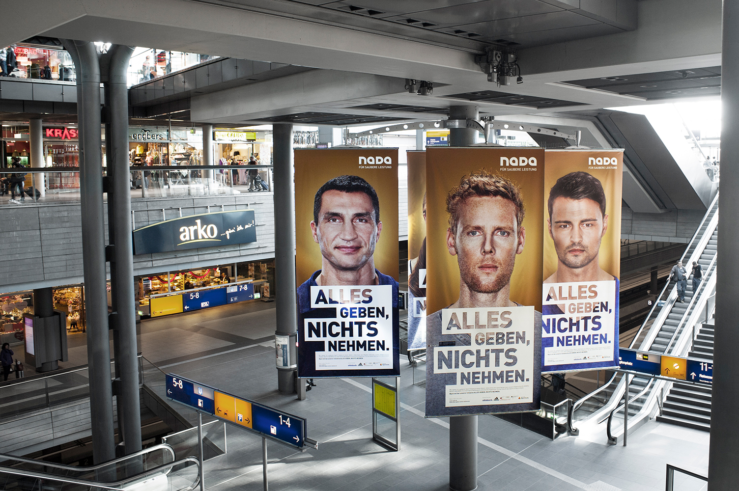 Three large NADA posters of Klitschko, Reckermann and Popow hang in Berlin's Central Station